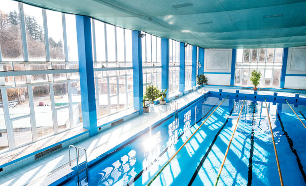 An interior of an indoor public swimming pool.