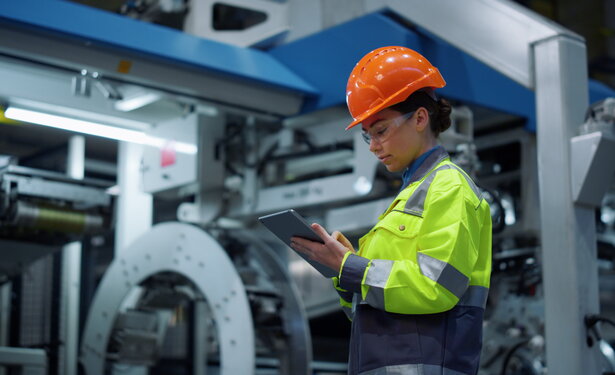 Engineer looking tablet computer in energy company. Modern factory concept.